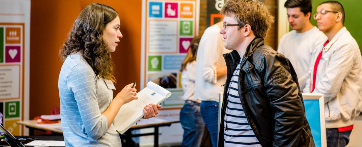 Student spreekt met vertegenwoordiger van een bedrijf tijdens de career launch. 