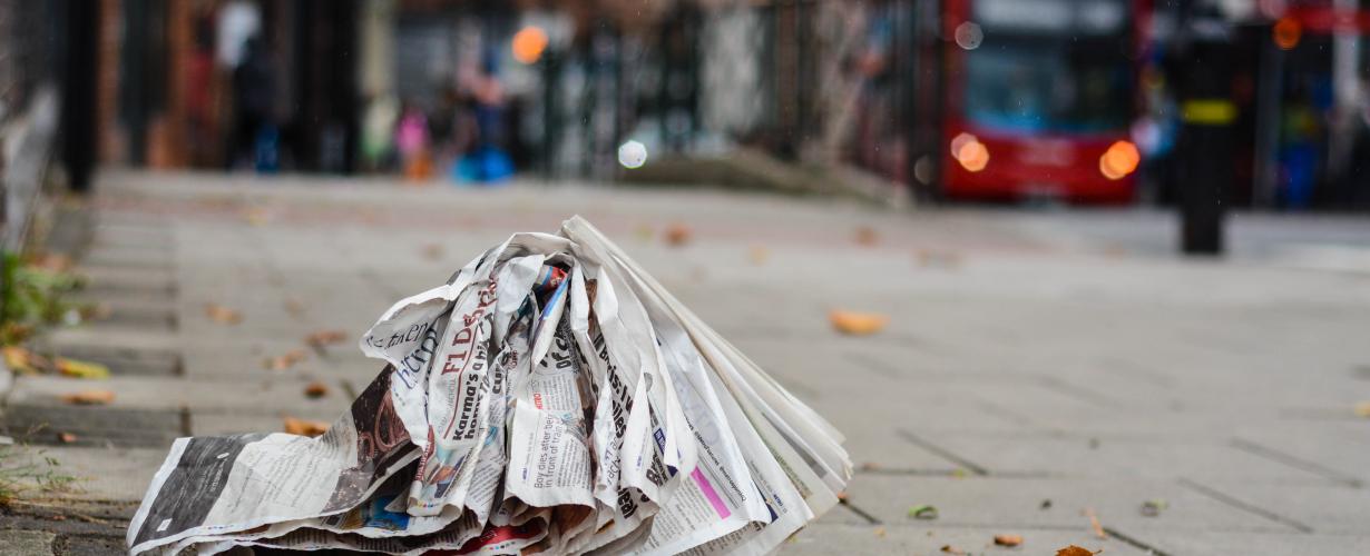 Een verfrommelde krant ligt op de straat