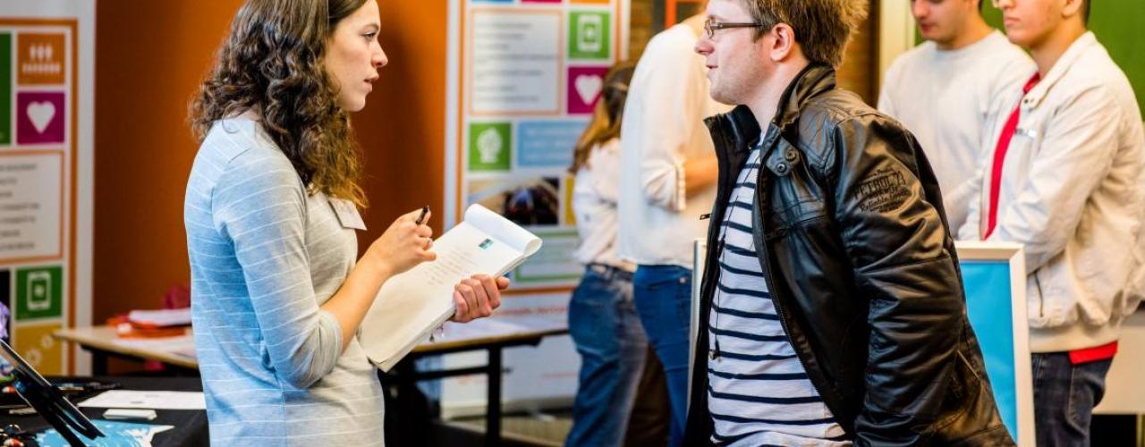 Student spreekt met vertegenwoordiger van een bedrijf tijdens de career launch. 