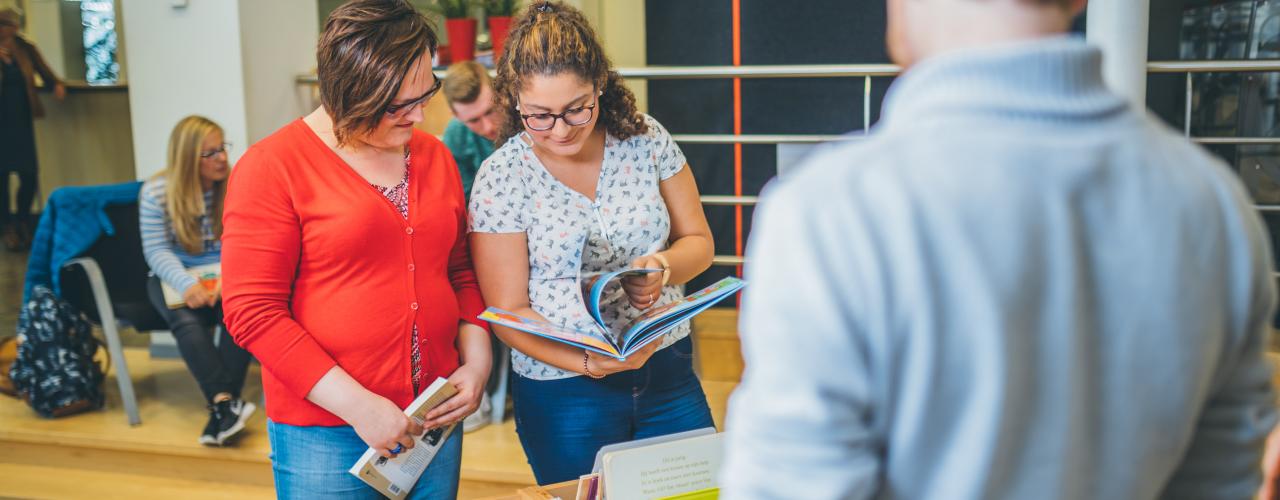 Studenten controleren de prentenboeken in de bibliotheek