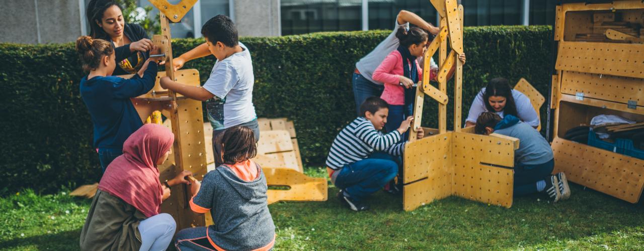 Kinderen werken samen aan een bouwstuk.