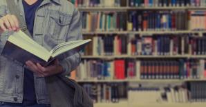 Persoon leest een boek voor een boekenrek