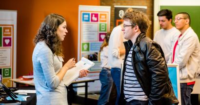 Student spreekt met vertegenwoordiger van een bedrijf tijdens de career launch. 