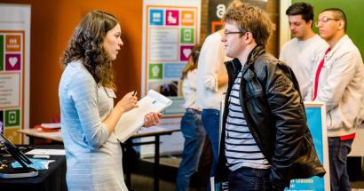 Student spreekt met vertegenwoordiger van een bedrijf tijdens de career launch. 