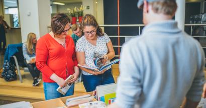 Studenten controleren de prentenboeken in de bibliotheek